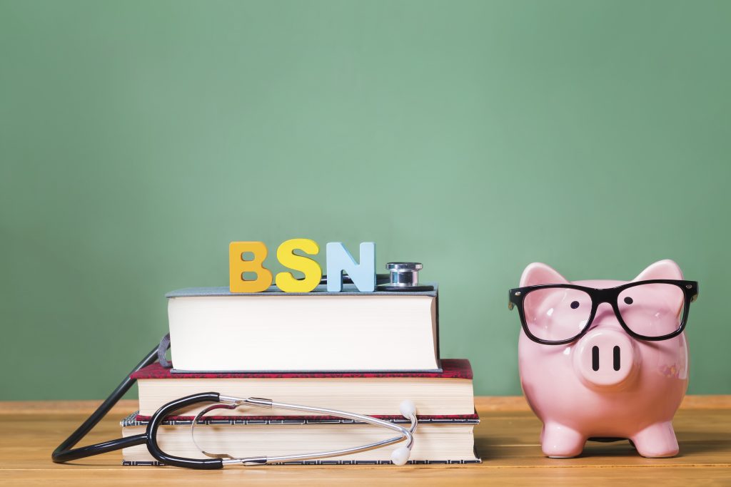 Bachelor of Science in Nursing BSN theme with pink piggy bank with chalkboard in the background as concept image of the costs of education