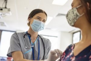 Support nurses - a picture of a nurses smiling under a COVID mask