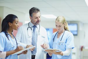 Conflict Resolution in Nursing- picture of a doctor speaking with two nurses