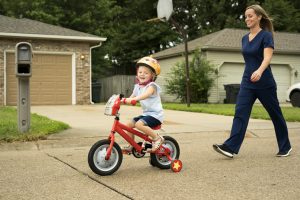 20 Things Prospective Nurses Need to Know a picture of a mom in scrubs with her daughter on a bike