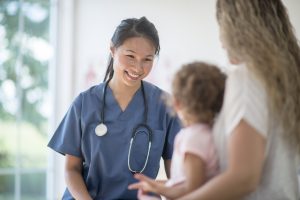 20 Things to Know a picture of a nurse smiling at a child