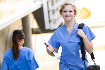 Why Become A Nurse - a picture of a young nurse walking