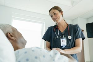 Nursing Quotes -- a picture of a RN smiling down at a patient.