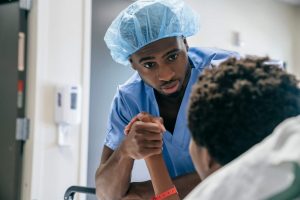 Nursing Quotes- a picture of a nurse holding the hand of a patient. 