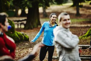 Attack Your Day! Before it Attacks You - a picture of a young woman smiling as she stretches before a morning workout.