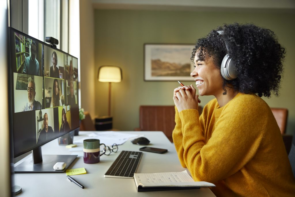 Attack Your Day! Before it Attacks You - a picture of a young woman smiling to her virtual/remote coworkers