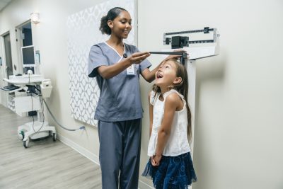 5 Dynamic Strategies for Creating the Nursing Career You Want - picture of a nurse measuring the height of a little girl patient.
