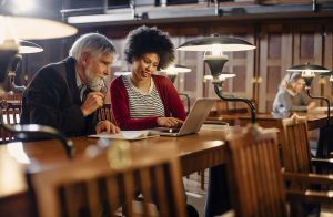 Master the Basics of APA - picture of a female student receiving help from a librarian.