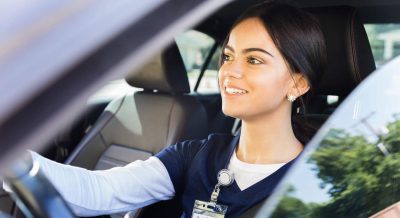 Compact Nursing States - a picture of a traveling nurse smiling in her car.