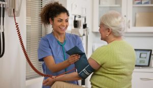 Float pool nurses - picture of a nurse checking a mature female patient's blood pressure.