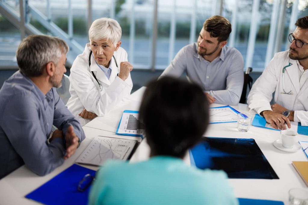 IRB: Friend or foe - picutre of a group of people discussing a topic around a table.
