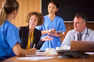 Administrative Healthcare Career Guide - a picture of a healthcare administrator speaking with medical team.