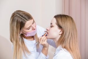 Aesthetics Nurse: A Comprehensive Guide - a picture of a nurse prepping for a lip treatment with a patient.