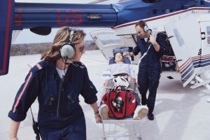 Flight nurse - a picture of a flight nurse with a patient on a helipad.