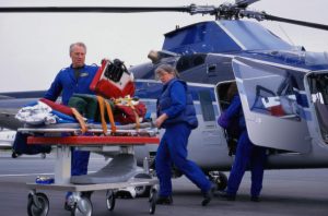 Flight nurse - a picture of a flight nurses preparing equipment and gear for a patient.