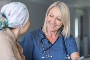 Hospice Nurse/ An informative career guide - a picture of a hospice nurse smiling back to a patient.