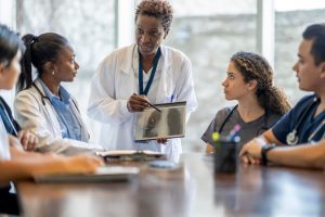 Nurse Teacher (aka Nurse Educator)_ The Complete Career Guide - a picture of a nurse educator teaching students about lung disease.