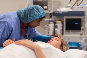 PACU (post-anesthesia care unit) Nurses Job Description and 2023 Outlook - a picture of a PACU nurse checking on her patient.