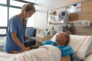 PACU (post-anesthesia care unit) Nurses Job Description and 2023 Outlook - a picture of a PACU nurse taking a patient's blood pressure.